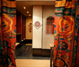 Umkleidebereich im Yogastudio mit bunten Vorhängen, Mandala-Dekor und warmem Licht. Umkleidebereich im Yogastudio mit bunten Vorhängen, Mandala-Dekor und warmem Licht.