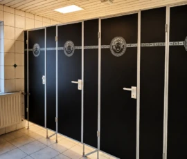 Gepflegte WC-Toilettenkabinen im Yogastudio mit schwarzen Türen und dekorativem Muster. Gepflegte WC-Toilettenkabinen im Yogastudio mit schwarzen Türen und dekorativem Muster.